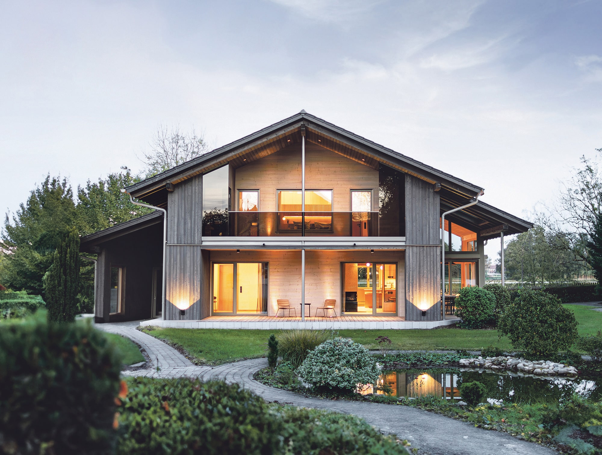 Massivholzhaus Satteldach mit großem Balkon und Garten als Musterhaus in Bayern