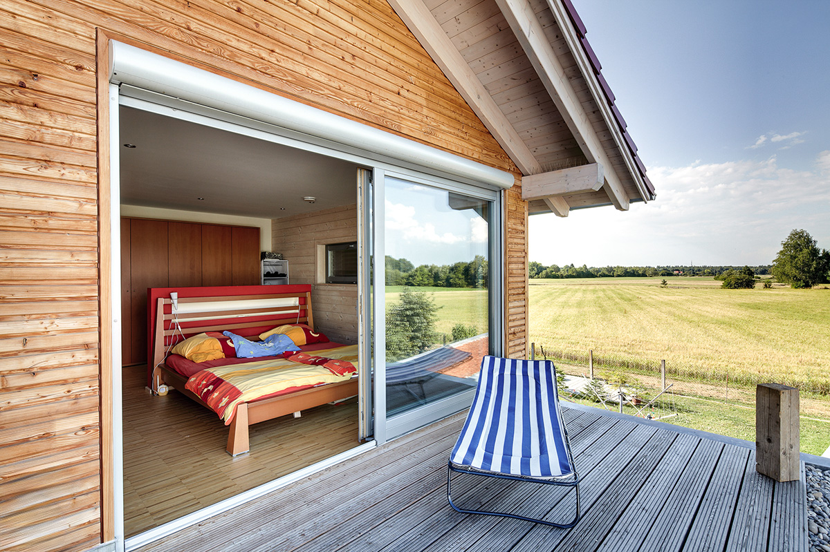 /files/dateien/H%C3%A4user/Kundenh%C3%A4user/Augsburg/modernes-holzhaus-augsburg-balkon-holzterrasse-traumaussicht-schlafzimmer.jpg