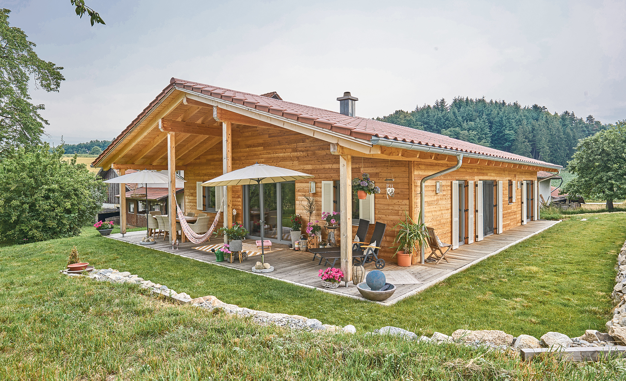 Zu sehen ist ein Bungalow, welches eine Fassade aus Holz hat.