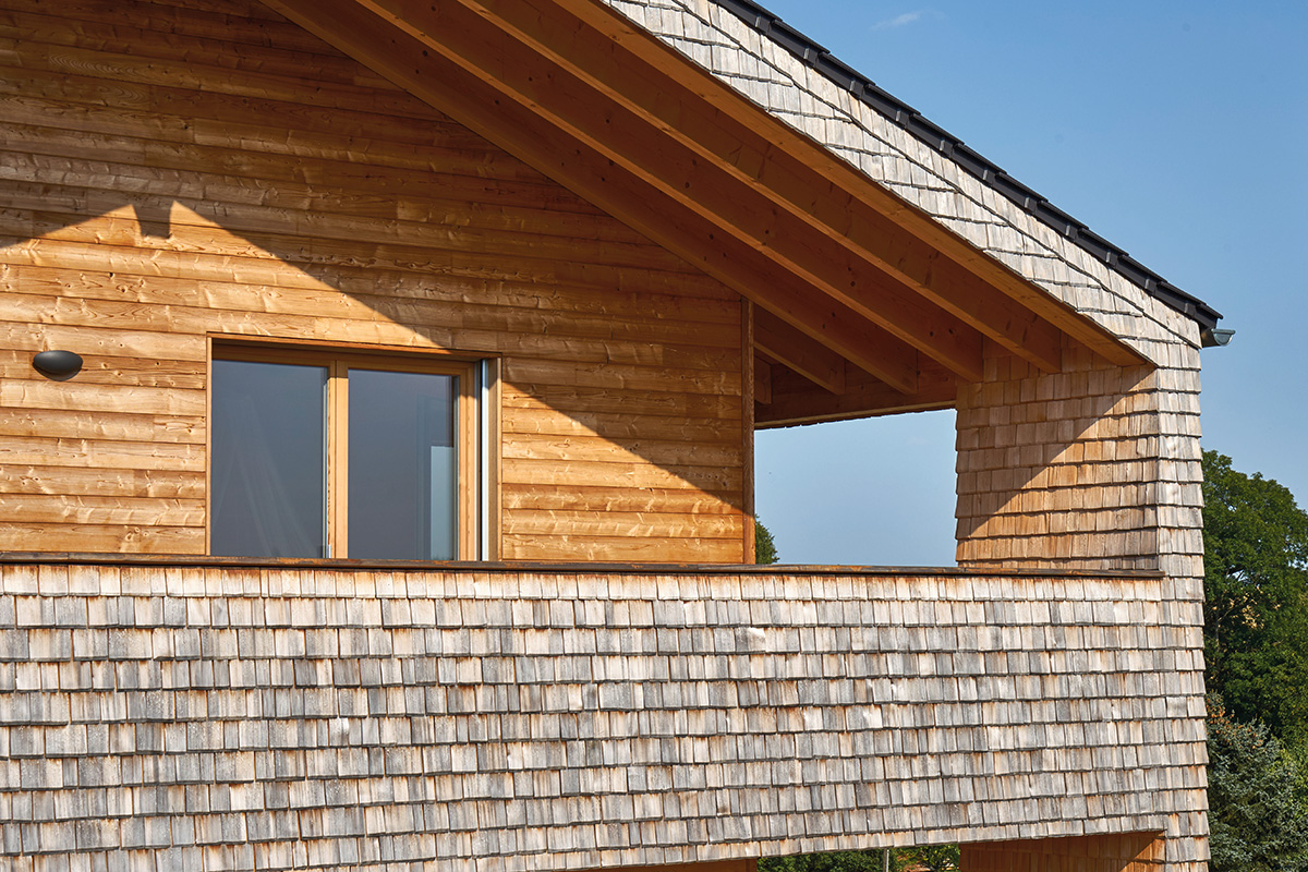 /files/dateien/H%C3%A4user/Kundenh%C3%A4user/Brunner/holzhaus-mit-holzschindeln-fassade-brunner-balkon-detail.jpg