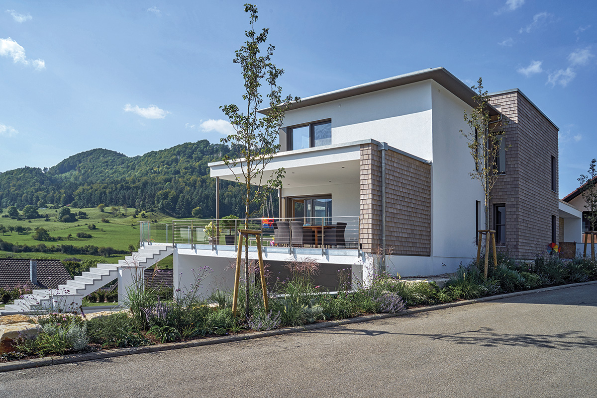 /files/dateien/H%C3%A4user/Kundenh%C3%A4user/Kornfeld/kubushaus-holz-kornfeld-seitenansicht-ueberdachte-umlaufende-terrasse-treppenaufgang.jpg