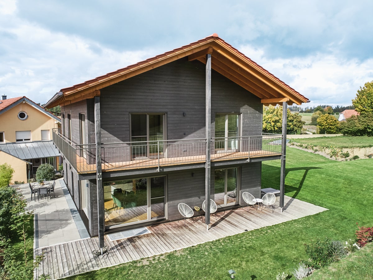 /files/dateien/H%C3%A4user/Kundenh%C3%A4user/M%C3%BChldorf/schwarzes-holzhaus-muehldorf-aussen-terrasse-balkon-ueber-zwei-seiten.jpg