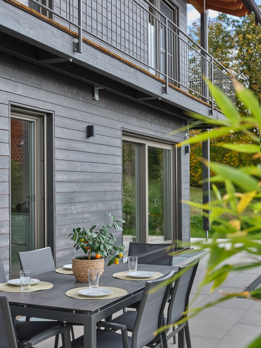 /files/dateien/H%C3%A4user/Kundenh%C3%A4user/M%C3%BChldorf/schwarzes-holzhaus-muehldorf-aussen-terrasse-grosse-fenster.jpg