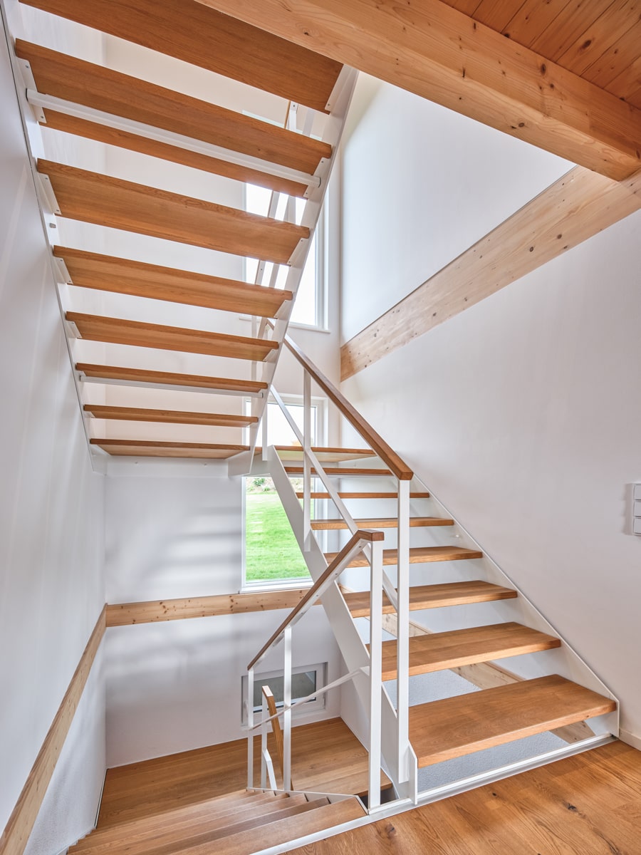 /files/dateien/H%C3%A4user/Kundenh%C3%A4user/M%C3%BChldorf/schwarzes-holzhaus-muehldorf-treppenaufgang-treppenhaus-weisses-und-natur-holz-gelaender.jpg