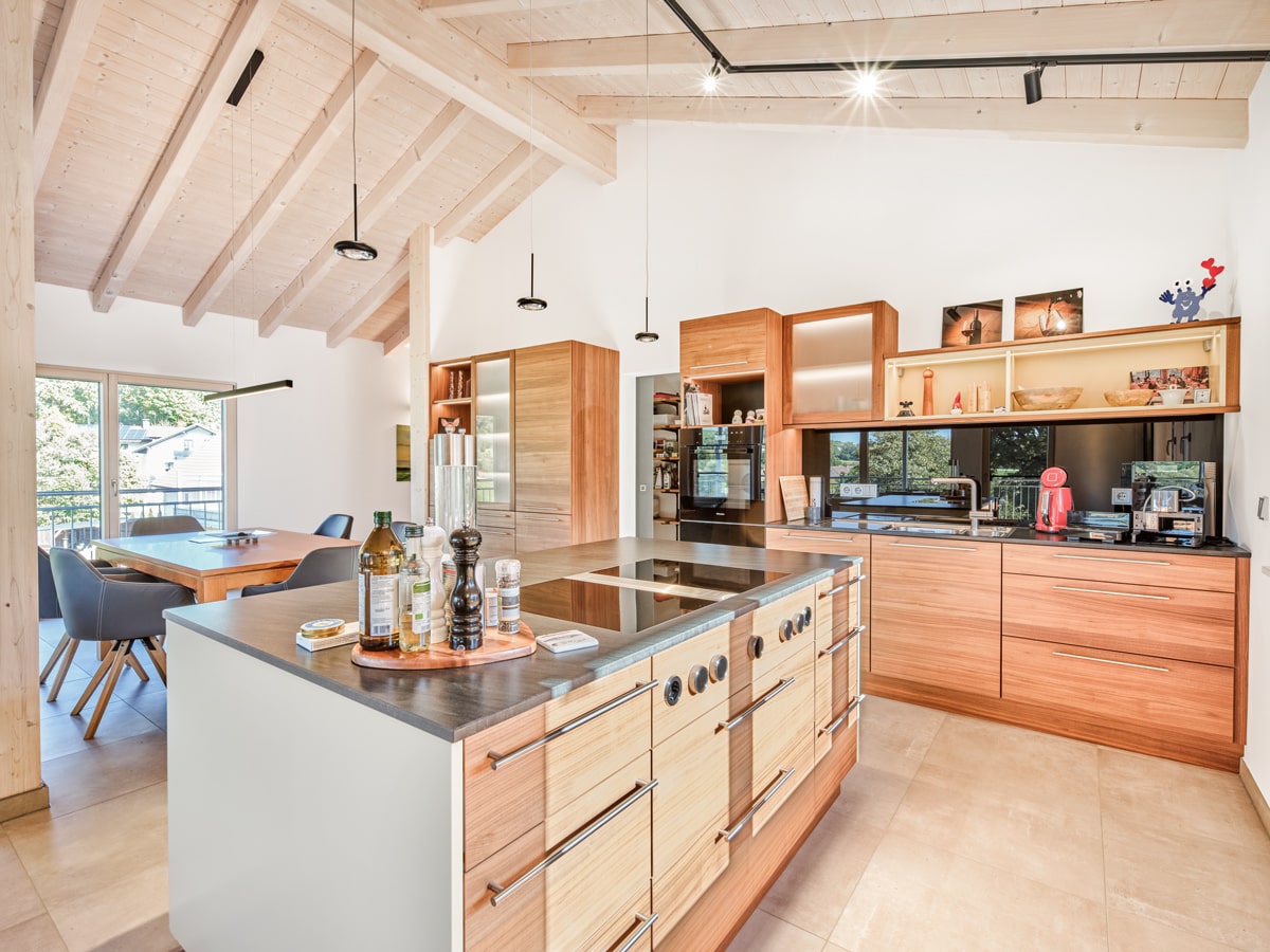 /files/dateien/H%C3%A4user/Kundenh%C3%A4user/Mehrfamilienhaus%20Beck%20mit%204%20Wohnungen/Detail-Slider/mehrfamilienhaus-4-wohnungen-aus-holz-dachgeschoss-offene-kueche-aus-eichenholz-nussbaumholz-mit-kuecheninsel.jpg