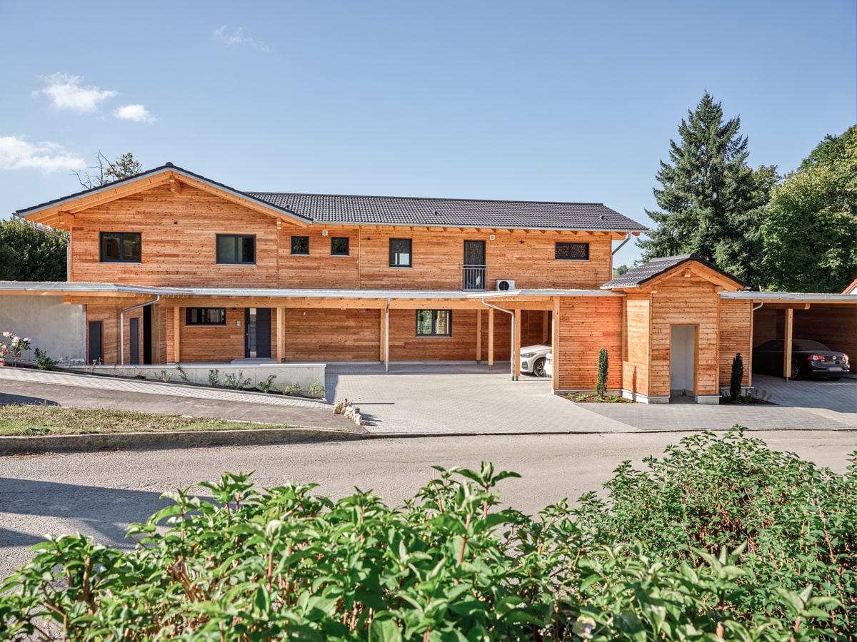 /files/dateien/H%C3%A4user/Kundenh%C3%A4user/Mehrfamilienhaus%20Beck%20mit%204%20Wohnungen/Detail-Slider/mehrfamilienhaus-aus-holz-mit-4-wohnungen-laerchenfassade-carport-eingangsbereich.jpg