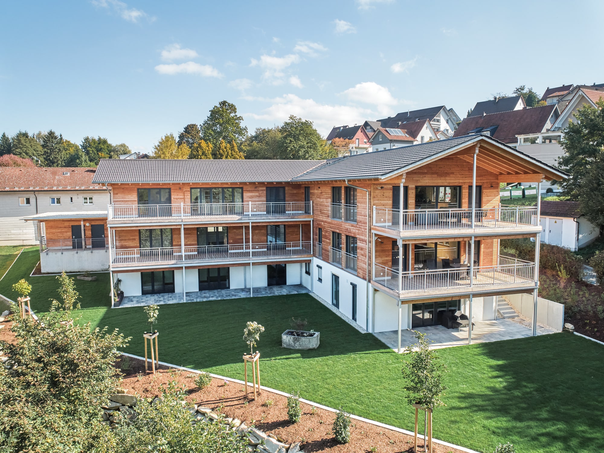 /files/dateien/H%C3%A4user/Kundenh%C3%A4user/Mehrfamilienhaus%20Beck%20mit%204%20Wohnungen/Titelbild/titelbild-mehrfamilienhaus-holzhaus-4-wohnungen-laerchenfassade-putzfassade-garten.jpg