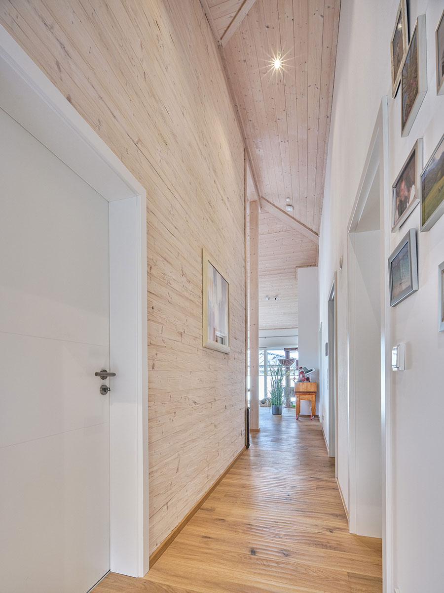 /files/dateien/H%C3%A4user/Kundenh%C3%A4user/Pfarrkirchen/Holzhaus-Pfarrkirchen_Bungalow_Hang_Flur-Massivholzwand-gehackt-gebeizt_01-min.jpg