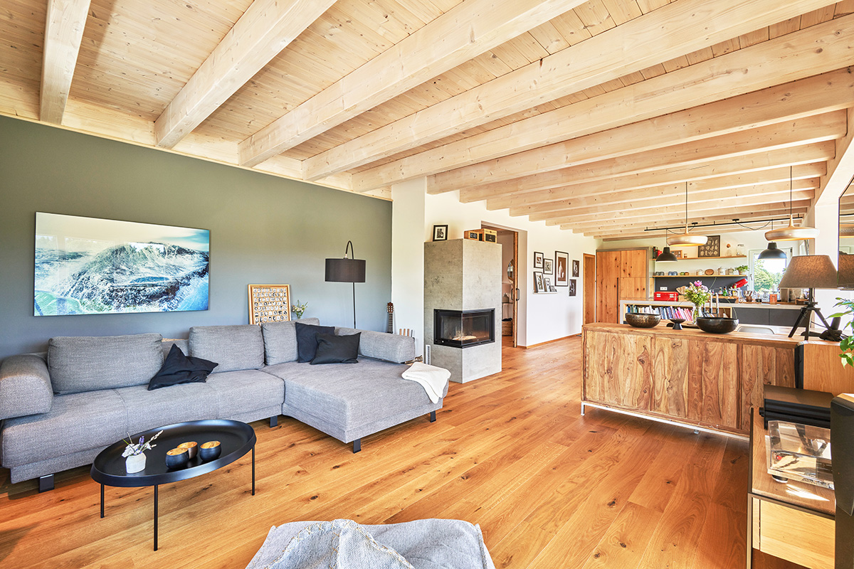 /files/dateien/H%C3%A4user/Kundenh%C3%A4user/Schliersee/Schliersee/oekohaus-landhaus-holzhaus-schliersee-offenes-wohn-esszimmer-sichtbalkendecke-kaminofen.jpg
