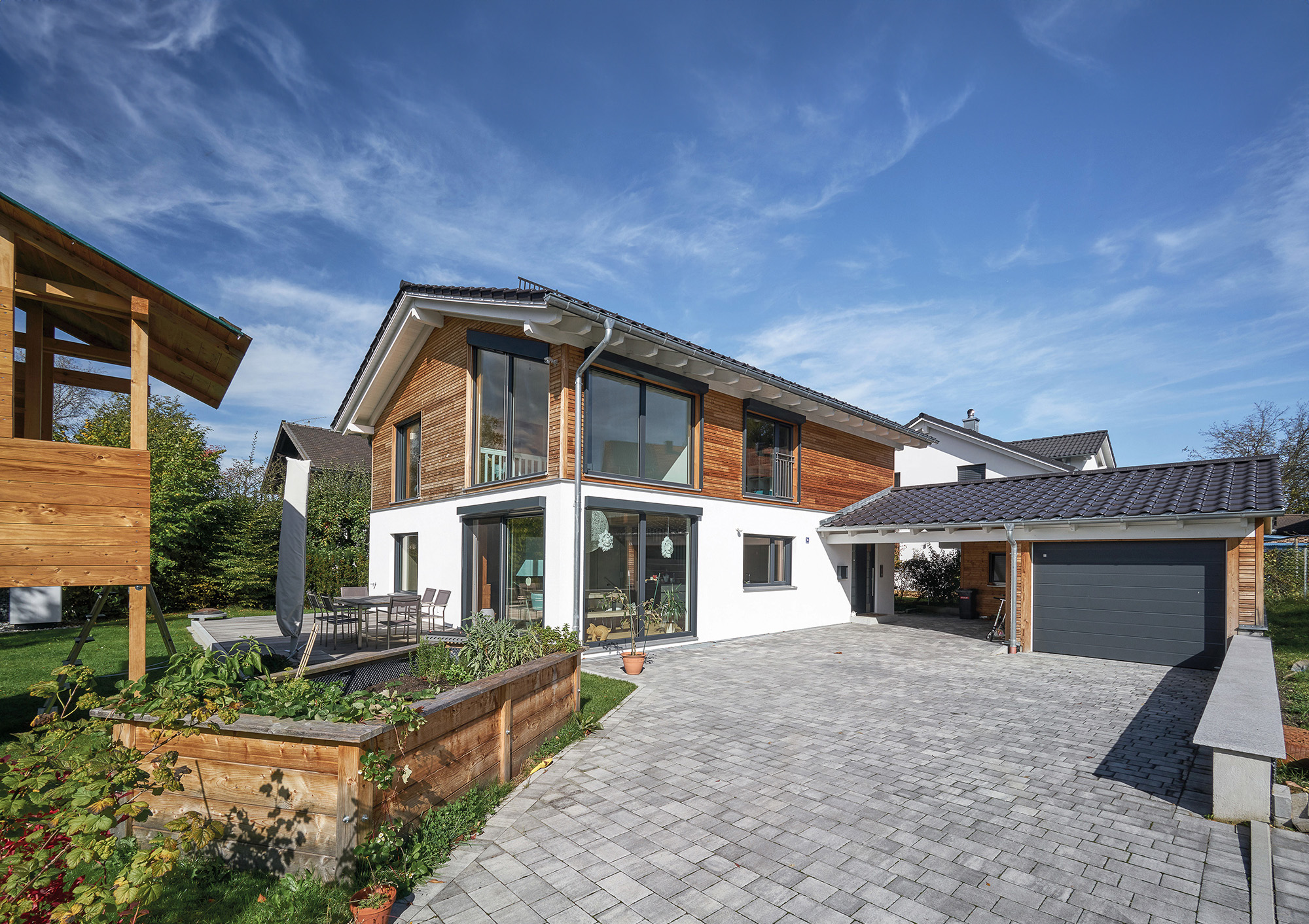 /files/dateien/H%C3%A4user/Kundenh%C3%A4user/Severin/modernes-holzhaus-einfamilienhaus-severin-einfahrt-uebereckfenster-holz-putz-fassade_2000.jpg