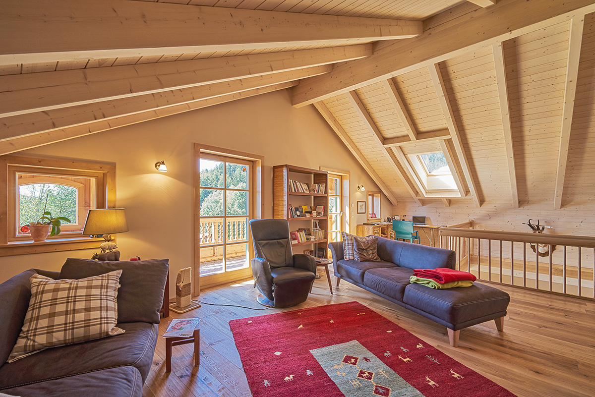 Gemütliches Wohnzimmer im Massivholzhaus Tirol mit Galerie