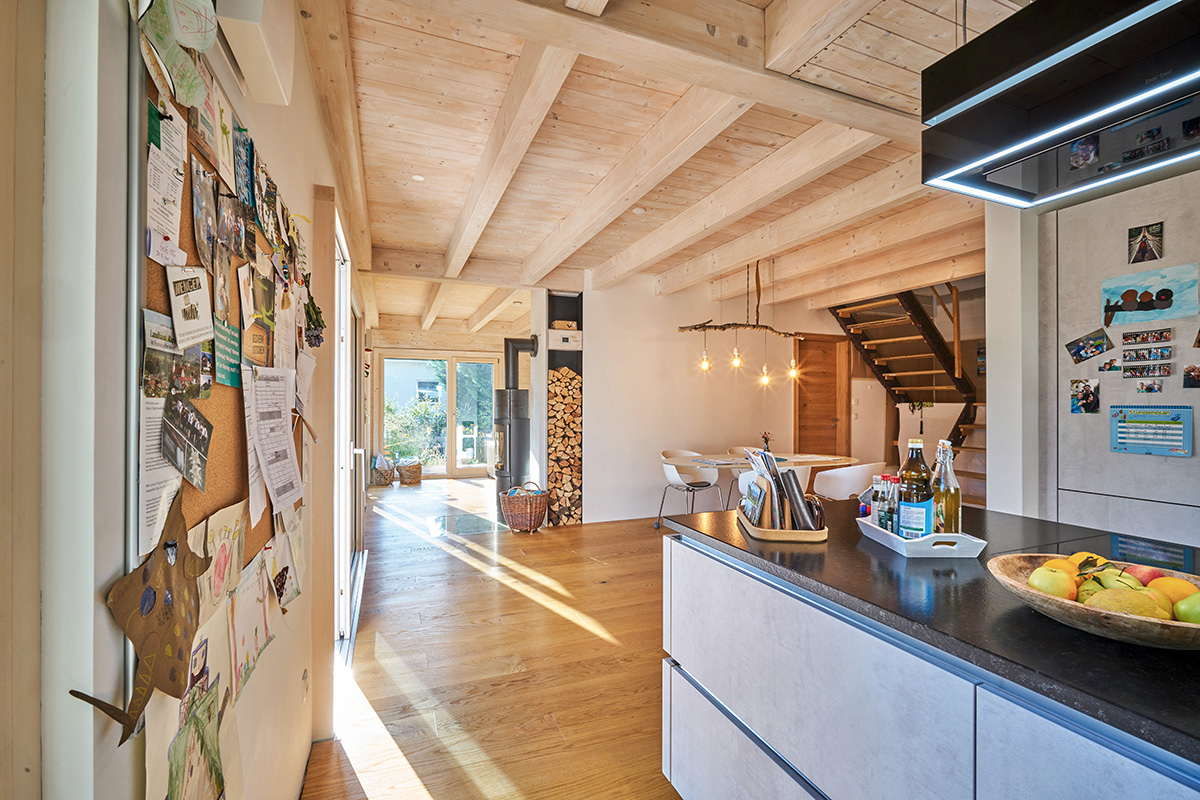 /files/dateien/H%C3%A4user/Kundenh%C3%A4user/Wittelsbach/holzhaus-wittelsbach-offener-wohnbereich-kueche-esszimmer-sichtbalkendecke-holzdecke.jpg