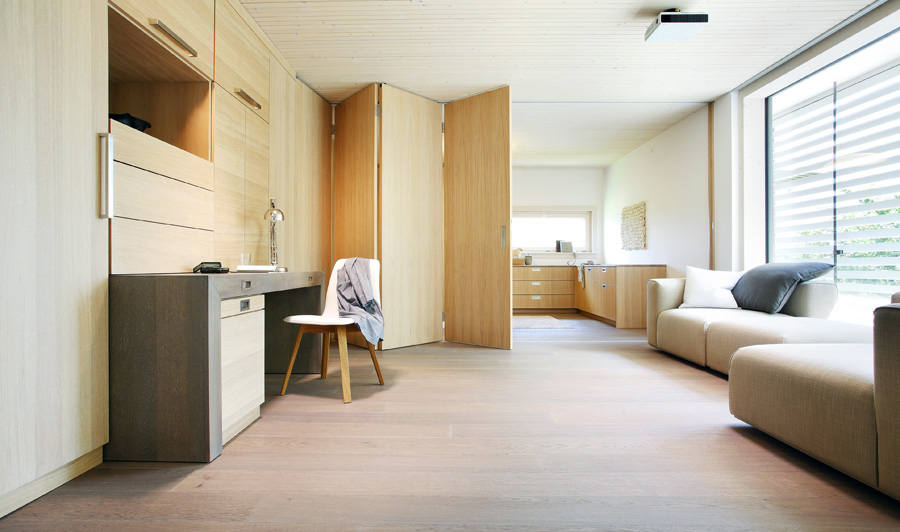 /files/dateien/H%C3%A4user/Musterh%C3%A4user/Musterhaus%20Functionality/plusenergiehaus-functionality-wohnbereich-faltbare-wand-buero-schreibtisch-schrank.jpg