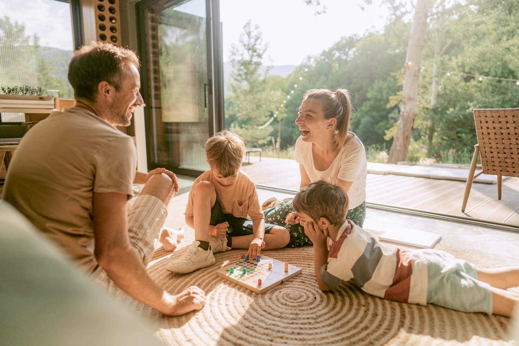 Zu sehen ist eine junge Familie, die ihre gemeinsame Zeit in einem Holzhaus verbringt.